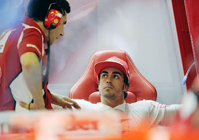 Fernando Alonso talking to a Ferrari team member 